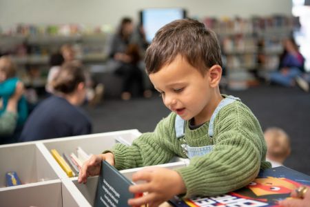 Boy looking through the children's books in the local library