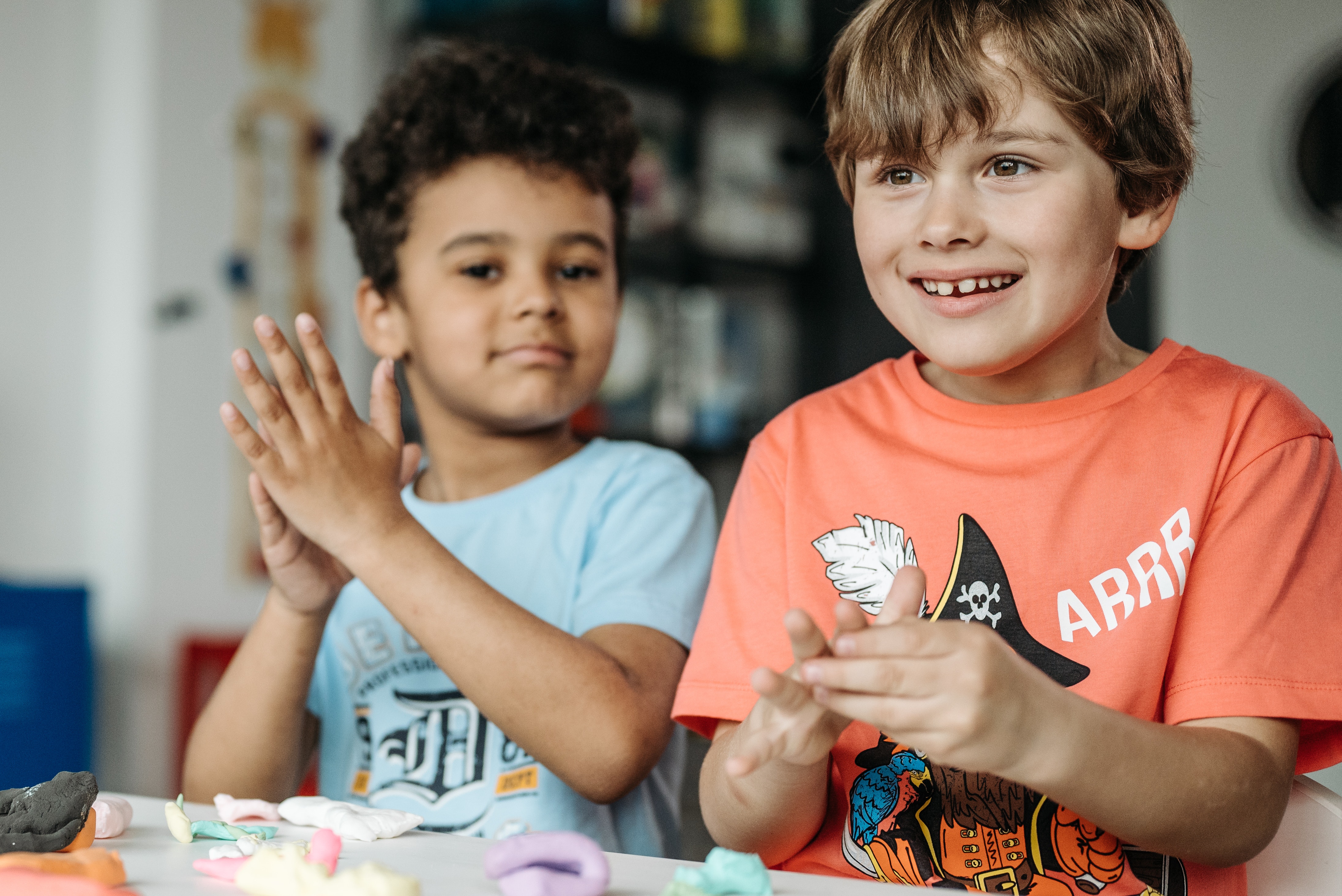Two boys moulding plasticine with their hands