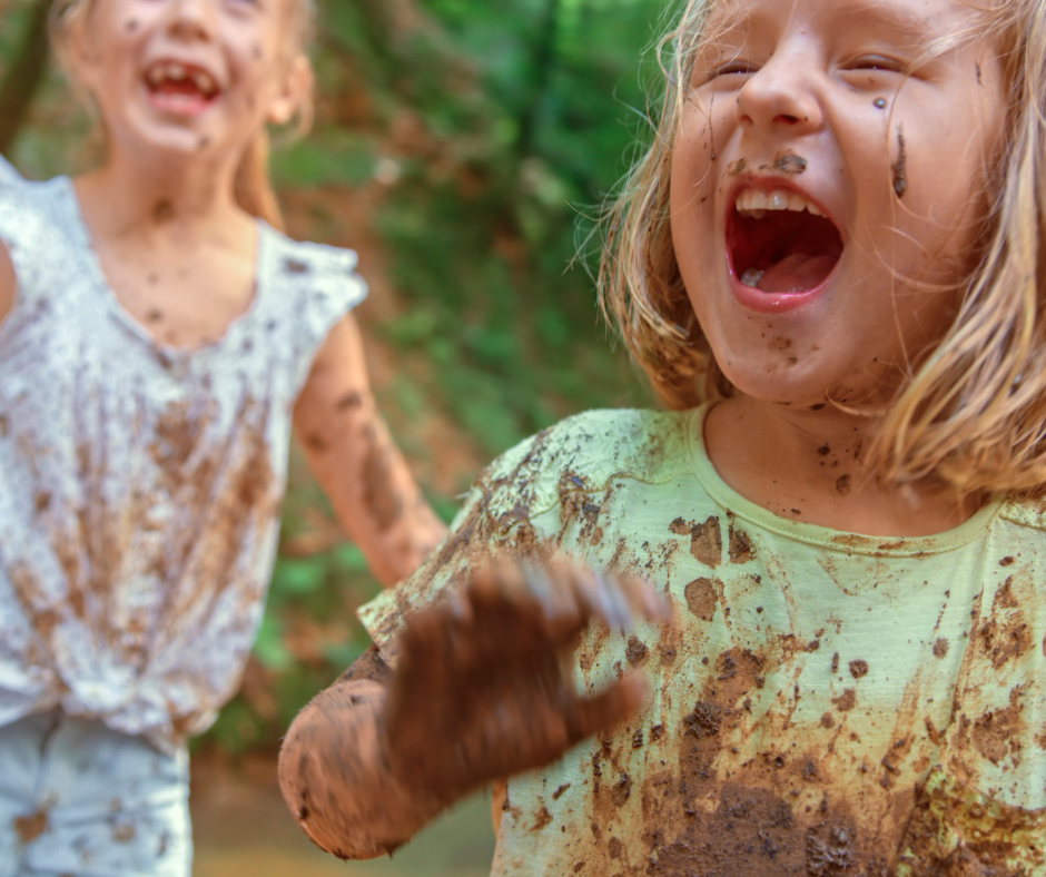 Two muddy children laughing