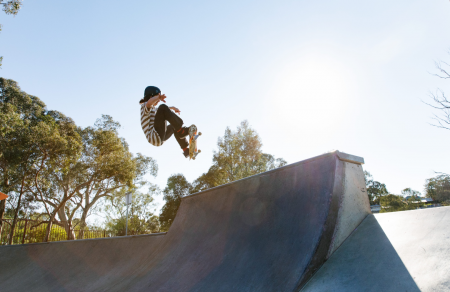 A skateboarding kid catching air off a ramp in Gawler