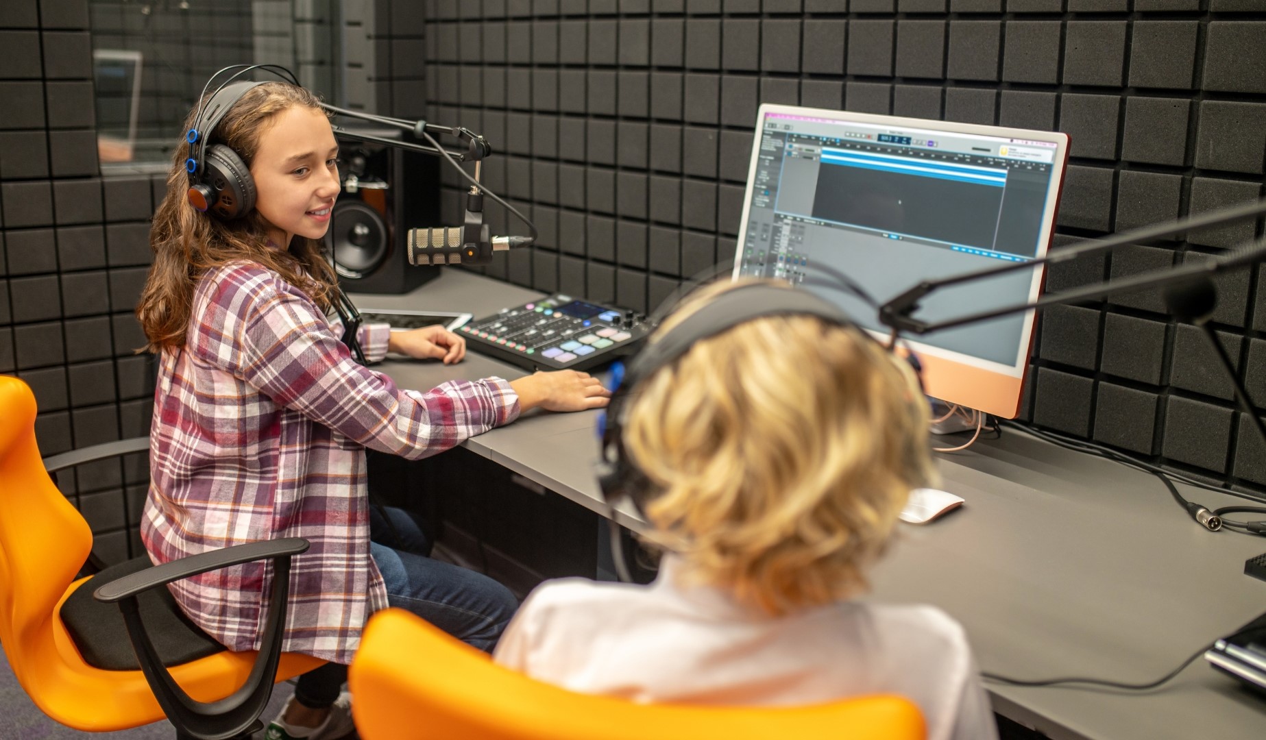 2 kids in a sound studio learning to make a podcast