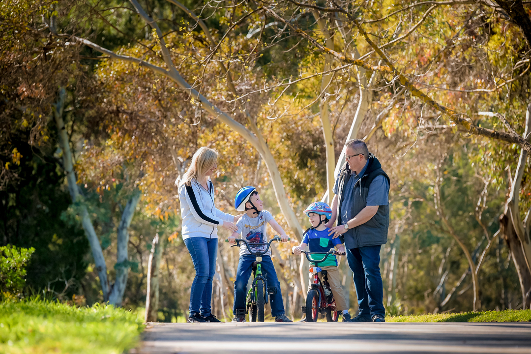 2 children on bikes with 2 adults on bike path