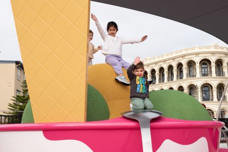 Child going down slide with arms up