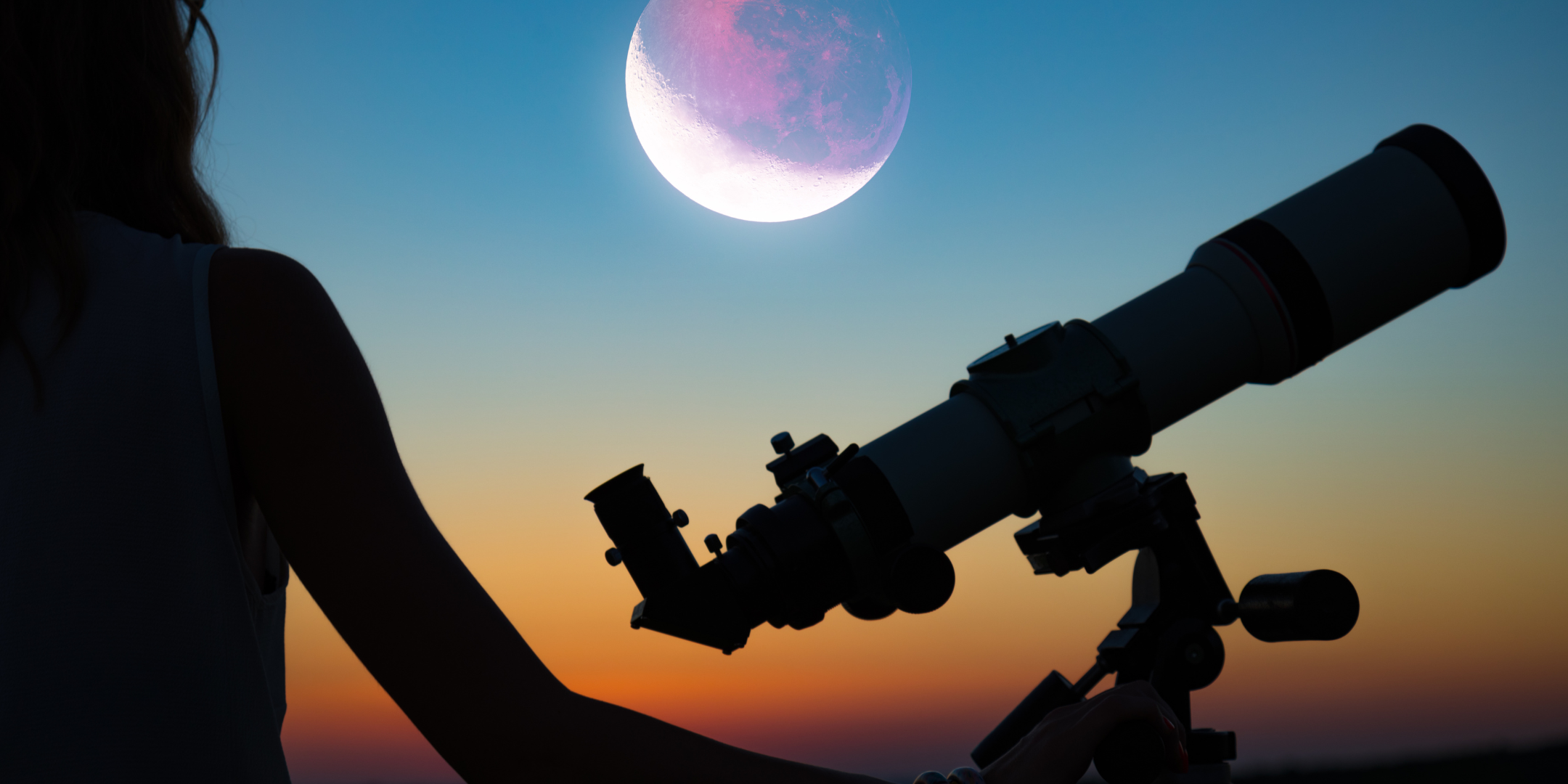 Silhouette of young person and telescope looking at moon