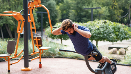 A man using the outdoor gym equipment